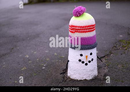 Decorazioni in maglia da snowmen su paletti a Pentyrch, Galles del Sud. Foto Stock