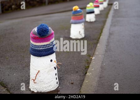 Decorazioni in maglia da snowmen su paletti a Pentyrch, Galles del Sud. Foto Stock