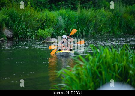 Bella coppia è in canoa solo nel fiume foresta, mentre cercando di tornare al loro gruppo Foto Stock