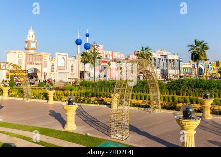 Dubai, Emirati Arabi Uniti, 10.01.21. Parco divertimenti Global Village a Dubai, passeggiata in legno con archi e lanterne illuminati e padiglioni nazionali. Foto Stock