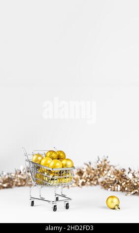 Carrello pieno di baubles giallo di Natale e composizione di tinsel con spazio copia. Foto Stock