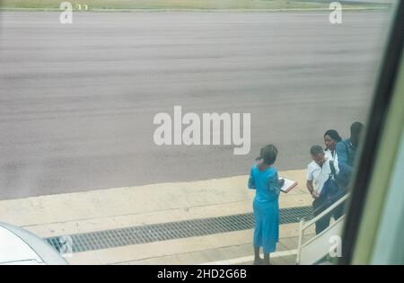 La stewardess congolese controlla il passeggero che entra nelle scale per l'aeroplano sul campo d'aviazione in Aeroporto Brazzaville. Foto Stock