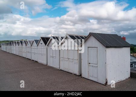 Hautot sur Mer, Francia - 30 luglio 2021: Spiaggia di sabbia con cabine di legno bianco a Hautot sur Mer Foto Stock