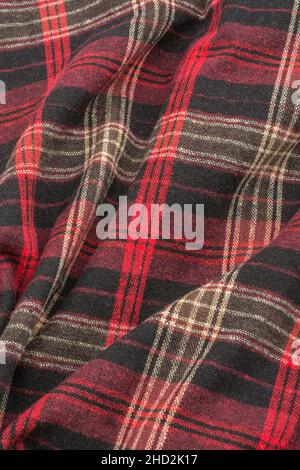 Primo piano del tessuto di flanella di controllo rosso, che mostra il modello di filo di trama e di ordito e cucitura arancione. Linea di punti, linee di punti Foto Stock