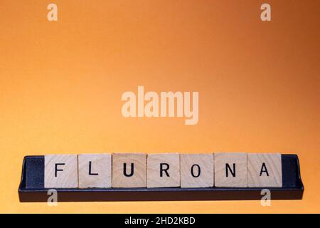Flurona-Flurone. Infezione da coronavirus (Covid-19) e influenza allo stesso tempo. Lettere scritte con sfondo arancione e con spazio per il testo. Orizzontale Foto Stock