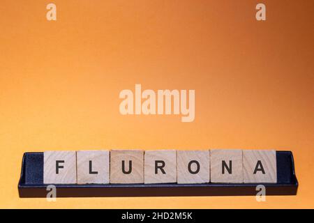 Flurona-Flurone. Infezione da coronavirus (Covid-19) e influenza allo stesso tempo. Lettere scritte con sfondo arancione e con spazio per il testo. Orizzontale Foto Stock