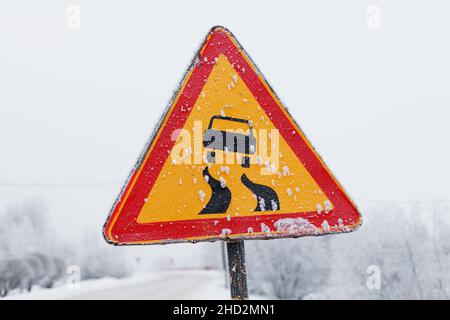 triangolo rosso con cartello stradale con un campo giallo con un'immagine di un'auto e una strada tortuosa Foto Stock