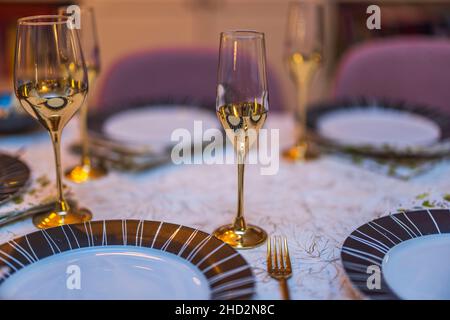 Bella vista del tavolo fesivamente set. Bicchieri da vino color oro in primo piano. Svezia. Foto Stock