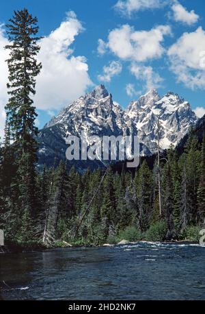 Le vette del Parco Nazionale del Grand Teton con acqua fluente in una giornata luminosa e soleggiata. Foto Stock