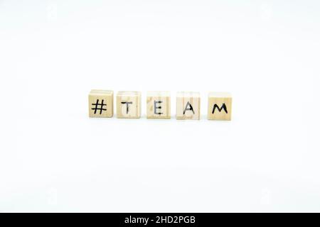 Word TEAM scritto sui cubi di legno su sfondo bianco. La foto di concetto con lettere #team Foto Stock