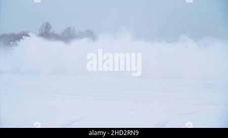 Strada nevosa in foresta con auto vicino e facendo un 180 giro slow motion . L'auto sta facendo una deriva nella neve. In inverno l'auto corre su una strada innevata. Foto Stock