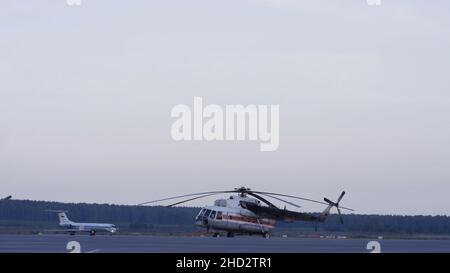 Lavoratori aeroportuali che gestiscono l'aeroplano. Aereo parcheggiato in aeroporto e preparazione per il volo successivo. Primo piano con vista alta su passeggero bianco moderno Foto Stock