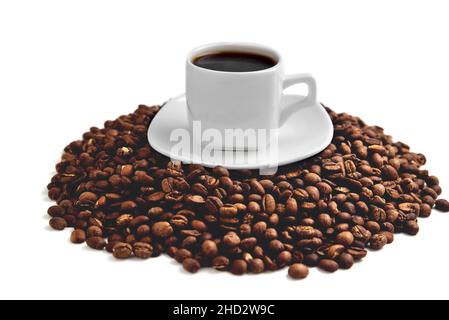 tazza di caffè bianca su un piatto bianco si trova su una collina di chicchi di caffè su uno sfondo bianco isolare, primo piano, angolo di vista dall'alto, fuoco selettivo Foto Stock