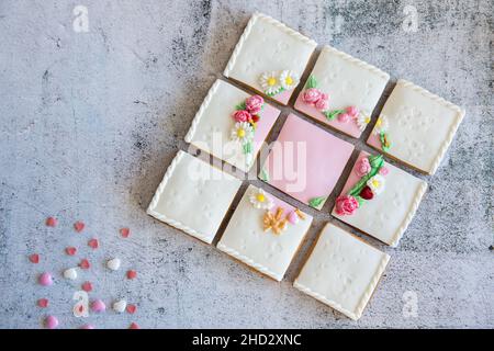 I biscotti di valentine di pan di zenzero si dividono in pezzi con delle spolverette su sfondo grigio. Copia spase, disposizione piatta Foto Stock