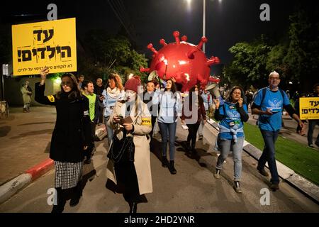 Raanana, Israele. 1st Gennaio 2022. Dimostrazione contro le restrizioni del virus di Corona, i vaccini infantili e la normativa “Green Badge/Pass”. La protesta iniziò nei pressi della residenza del primo ministro Bennett a Raanana, e marciò verso un centro commerciale nella città di Kfar Saba, bloccando le strade principali e gli incroci. La settimana scorsa il governo israeliano ha legiferato sulle nuove restrizioni, impedendo ai cittadini senza passaporto verde di entrare nei negozi dei centri commerciali, oltre ai servizi essenziali, come il cibo e le farmacie. Raánana, Israele. 01th Jan 2022. Credit: Matan Golan/Alamy Live News Foto Stock