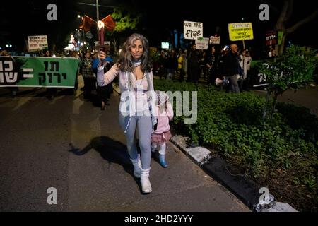 Raanana, Israele. 1st Gennaio 2022. Dimostrazione contro le restrizioni del virus di Corona, i vaccini infantili e la normativa “Green Badge/Pass”. La protesta iniziò nei pressi della residenza del primo ministro Bennett a Raanana, e marciò verso un centro commerciale nella città di Kfar Saba, bloccando le strade principali e gli incroci. La settimana scorsa il governo israeliano ha legiferato sulle nuove restrizioni, impedendo ai cittadini senza passaporto verde di entrare nei negozi dei centri commerciali, oltre ai servizi essenziali, come il cibo e le farmacie. Raánana, Israele. 01th Jan 2022. Credit: Matan Golan/Alamy Live News Foto Stock