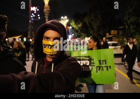 Raanana, Israele. 1st Gennaio 2022. Dimostrazione contro le restrizioni del virus di Corona, i vaccini infantili e la normativa “Green Badge/Pass”. La protesta iniziò nei pressi della residenza del primo ministro Bennett a Raanana, e marciò verso un centro commerciale nella città di Kfar Saba, bloccando le strade principali e gli incroci. La settimana scorsa il governo israeliano ha legiferato sulle nuove restrizioni, impedendo ai cittadini senza passaporto verde di entrare nei negozi dei centri commerciali, oltre ai servizi essenziali, come il cibo e le farmacie. Raánana, Israele. 01th Jan 2022. Credit: Matan Golan/Alamy Live News Foto Stock