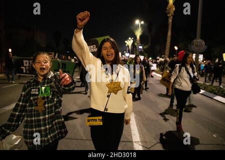 Raanana, Israele. 1st Gennaio 2022. Dimostrazione contro le restrizioni del virus di Corona, i vaccini infantili e la normativa “Green Badge/Pass”. La protesta iniziò nei pressi della residenza del primo ministro Bennett a Raanana, e marciò verso un centro commerciale nella città di Kfar Saba, bloccando le strade principali e gli incroci. La settimana scorsa il governo israeliano ha legiferato sulle nuove restrizioni, impedendo ai cittadini senza passaporto verde di entrare nei negozi dei centri commerciali, oltre ai servizi essenziali, come il cibo e le farmacie. Raánana, Israele. 01th Jan 2022. Credit: Matan Golan/Alamy Live News Foto Stock