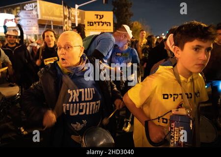 Raanana, Israele. 1st Gennaio 2022. Dimostrazione contro le restrizioni del virus di Corona, i vaccini infantili e la normativa “Green Badge/Pass”. La protesta iniziò nei pressi della residenza del primo ministro Bennett a Raanana, e marciò verso un centro commerciale nella città di Kfar Saba, bloccando le strade principali e gli incroci. La settimana scorsa il governo israeliano ha legiferato sulle nuove restrizioni, impedendo ai cittadini senza passaporto verde di entrare nei negozi dei centri commerciali, oltre ai servizi essenziali, come il cibo e le farmacie. Raánana, Israele. 01th Jan 2022. Credit: Matan Golan/Alamy Live News Foto Stock