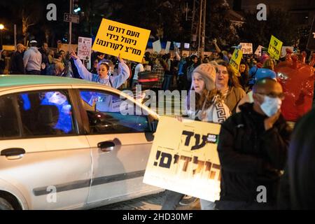 Raanana, Israele. 1st Gennaio 2022. Dimostrazione contro le restrizioni del virus di Corona, i vaccini infantili e la normativa “Green Badge/Pass”. La protesta iniziò nei pressi della residenza del primo ministro Bennett a Raanana, e marciò verso un centro commerciale nella città di Kfar Saba, bloccando le strade principali e gli incroci. La settimana scorsa il governo israeliano ha legiferato sulle nuove restrizioni, impedendo ai cittadini senza passaporto verde di entrare nei negozi dei centri commerciali, oltre ai servizi essenziali, come il cibo e le farmacie. Raánana, Israele. 01th Jan 2022. Credit: Matan Golan/Alamy Live News Foto Stock