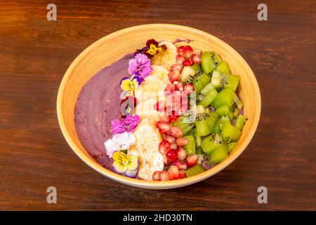 Ciotola sana di yogurt con frutta, kiwi maturi, banane e cereali di melograno Foto Stock