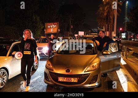 Raanana, Israele. 1st Gennaio 2022. Dimostrazione contro le restrizioni del virus di Corona, i vaccini infantili e la normativa “Green Badge/Pass”. La protesta iniziò nei pressi della residenza del primo ministro Bennett a Raanana, e marciò verso un centro commerciale nella città di Kfar Saba, bloccando le strade principali e gli incroci. La settimana scorsa il governo israeliano ha legiferato sulle nuove restrizioni, impedendo ai cittadini senza passaporto verde di entrare nei negozi dei centri commerciali, oltre ai servizi essenziali, come il cibo e le farmacie. Raánana, Israele. 01th Jan 2022. Credit: Matan Golan/Alamy Live News Foto Stock