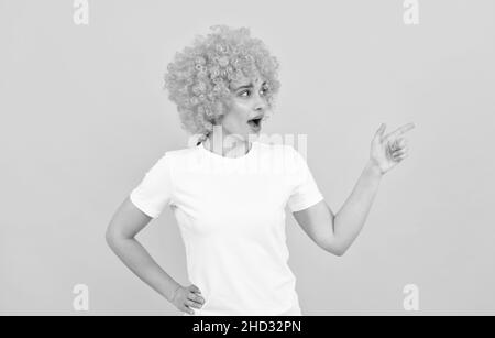 guardate là. stupito aspetto di festa fantasia. donna freaky in clown wig puntando dito, copia spazio Foto Stock