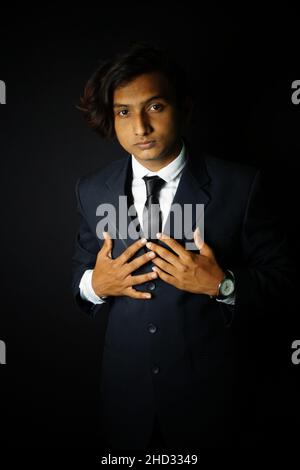 Colpo verticale di un uomo indiano che indossa un abito e un orologio di classe Foto Stock
