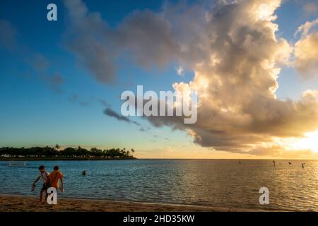 Honolulu, Hawaii - 2 dicembre 2021: Tramonto sull'oceano visto da Ala Moana Beach e dal Parco Regionale. La gente si gode la calda serata Foto Stock