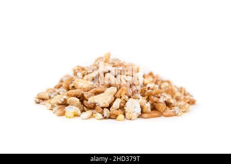 Fiocchi di grani in un mucchio, primo piano. Macro di cereali misti in fiocchi e non imbevuti, fatti con un sfornatore di grano o un mulino di grano. Chicchi di grano duro, sorgo Foto Stock