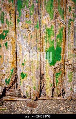 Un colpo verticale di una vecchia porta di legno con vernice verde Foto Stock