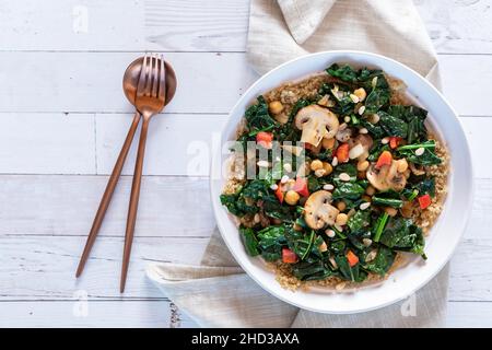 Una ciotola di supercibo appena saltata su un tavolo di legno, pronta per mangiare. Foto Stock