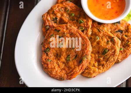 Torta di pesce fritta, primo piano Thailandesi food Thod Mun o torta di pesce fritto con salsa dolce, immagine dall'alto del tradizionale cibo thailandese. Foto Stock