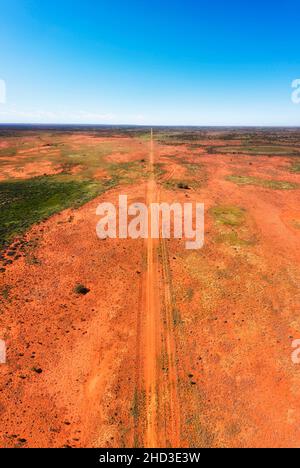 Infinite pianure dell'entroterra australiano semi deserto intorno a collina rotta in un panorama aereo verticale in alto lungo la pista sterrata. Foto Stock