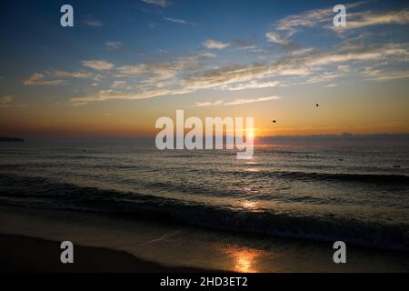 Onde dolci mentre il sole sorge sul Mar Nero nella località di Obzor in Bulgaria in una tranquilla e calda giornata estiva. Foto Stock