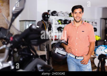 Ritratto di un cliente maschile che sta posando in un nuovo casco Foto Stock