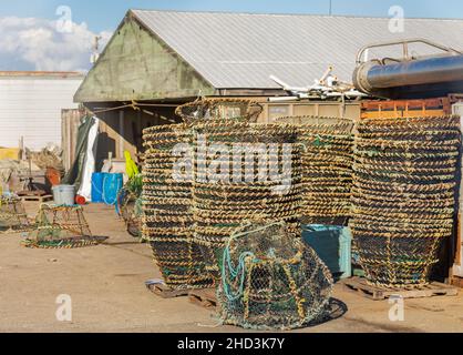 Trappola di pesce per la pesca di aragoste e granchi. Primo piano di cesti utilizzati per la cattura e la pesca di gamberi, impilati su un lato della casa di pesca. Vista sulla strada, Foto Stock