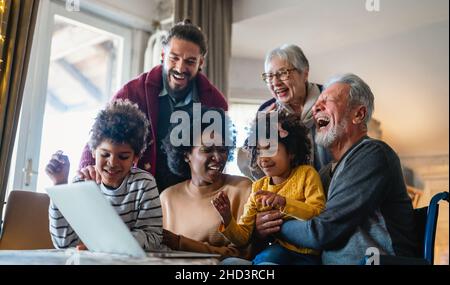 Ritratto di una felice famiglia multigenerazionale multietnica in casa. Foto Stock