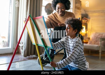 Bambino felice che fa le esercitazioni di matematica con la sua madre ot insegnante insieme. Concetto di divertimento per le persone che si educano Foto Stock