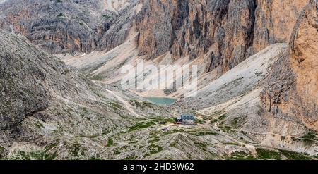 Rifugio Antermoia e Lago di Antermoia con scoscese rocce intorno al monte Mantel in montagna Dolomiti in Italia Foto Stock