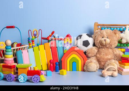 Collezione di giocattoli per bambini isolati su sfondo blu. Orsacchiotto, in legno, plastica e morbido set di giocattoli per bambini. Vista frontale Foto Stock
