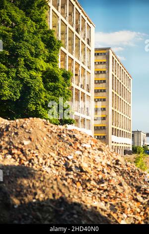 Calcestruzzo industriale distrutto da sciopero. Scenario di disastro pieno di detriti, polvere e edifici schiacciati. Foto Stock