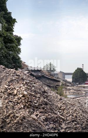 Calcestruzzo industriale distrutto da sciopero. Scenario di disastro pieno di detriti, polvere e edifici schiacciati. Foto Stock