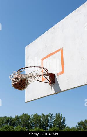 Basket sparato su un cerchio contro un cielo blu chiaro Foto Stock