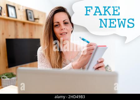 Ispirazione per firmare Fake News. Internet Concept false informazioni pubblicano sotto il pretesto di essere notizie autentiche guardando documentari online Foto Stock