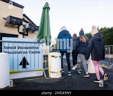 Una madre porta le sue tre figlie nel centro di vaccinazione del Glengarn Hotel a Castleblaney, County Monaghan. I genitori in Irlanda possono ora registrare i bambini di età compresa tra i 5 e i 11 anni per i vaccini Covid-19, con il lancio previsto per iniziare con preminenza. Foto Stock