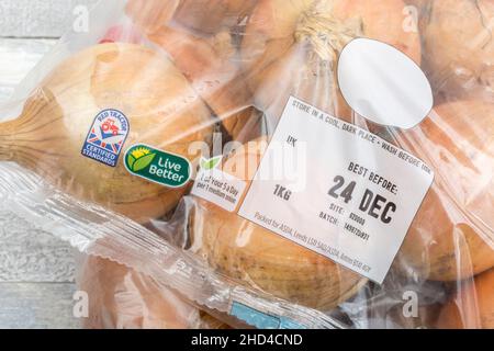 CIPOLLE marroni / Allium cepa confezionate in plastica ASDA. Chiamato anche cipolle gialle + etichetta Best Before Date / BBD. Per ingredienti comuni della cucina e medicinali. Foto Stock