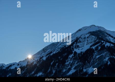 Saint Margrethenberg, Svizzera, 19 dicembre 2021 bellissimo tramonto dietro il panorama nevoso della montagna Foto Stock