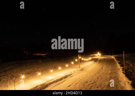 Saint Margrethenberg, Svizzera, 19 dicembre 2021 strada pedonale coperta di neve di notte illuminata con luci Foto Stock