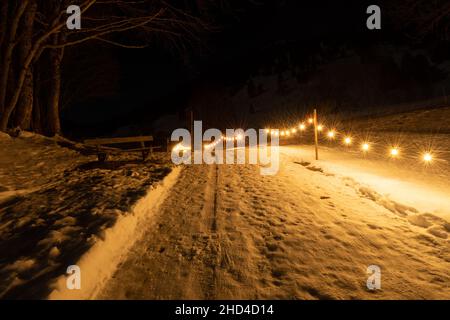 Saint Margrethenberg, Svizzera, 19 dicembre 2021 strada pedonale coperta di neve di notte illuminata con luci Foto Stock